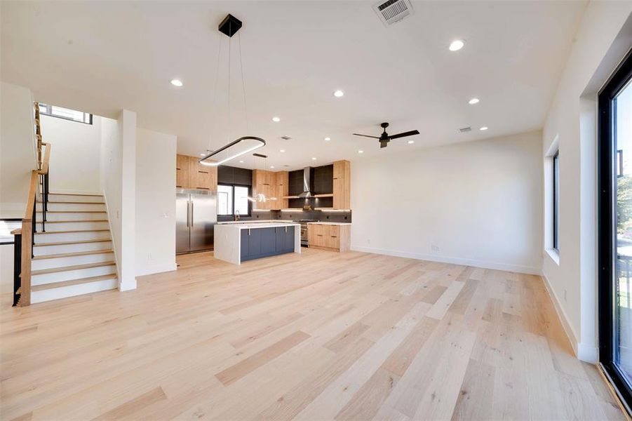 Unfurnished living room with ceiling fan, light hardwood / wood-style floors, and sink