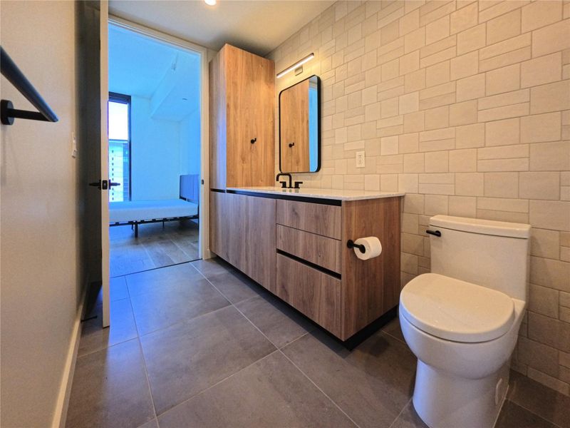 Bathroom with vanity, tile patterned floors, and tile walls Bathroom with vanity, tile patterned floors, and tile walls
