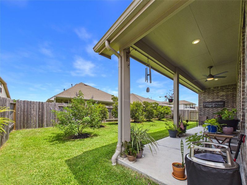The covered back patio offers a comfortable place to relax and enjoy the backyard. Mature landscaping and thoughtfully placed greenery add natural privacy, creating a peaceful outdoor setting that feels tucked away while still leaving plenty of open yard space to enjoy.