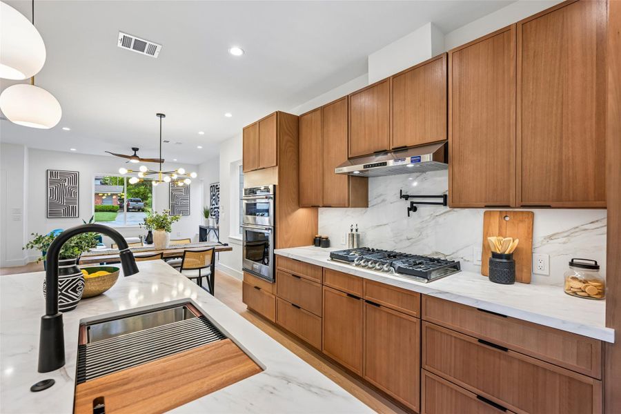Kitchen featuring a gas cooktop, pot filler, and spacious island for entertaining.