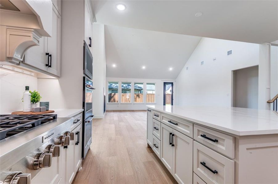 Kitchen with recessed lighting, stainless steel appliances, white cabinetry, a kitchen island, and light wood-type flooring