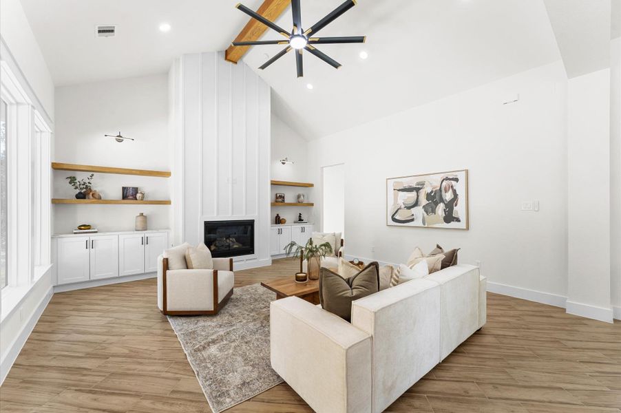 Grand living area with cathedral ceiling, cozy chimney, large windows for natural light, and open flow to the kitchen and dining—perfect for entertaining. Grand living area with cathedral ceiling, cozy chimney, large windows for natural light, and open flow to the kitchen and dining—perfect for entertaining.