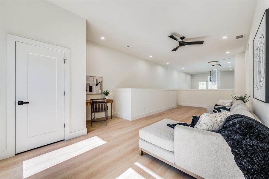 Living room featuring ceiling fan and light hardwood / wood-style floors