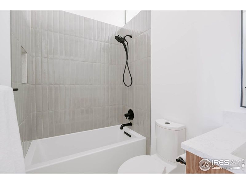 Main floor bathroom with vertical subway tile in the tub shower enclosure