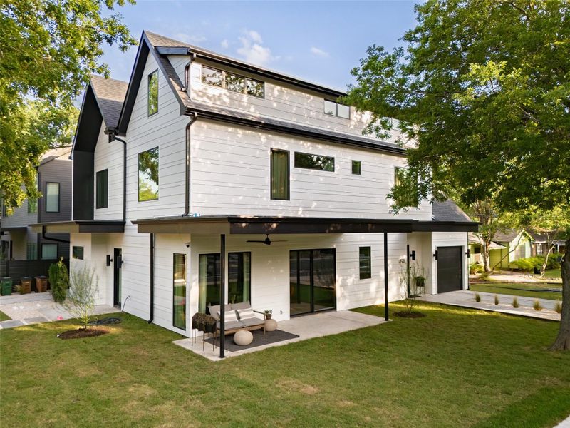 Back of property featuring a lawn, a ceiling fan, a shingled roof, and a patio