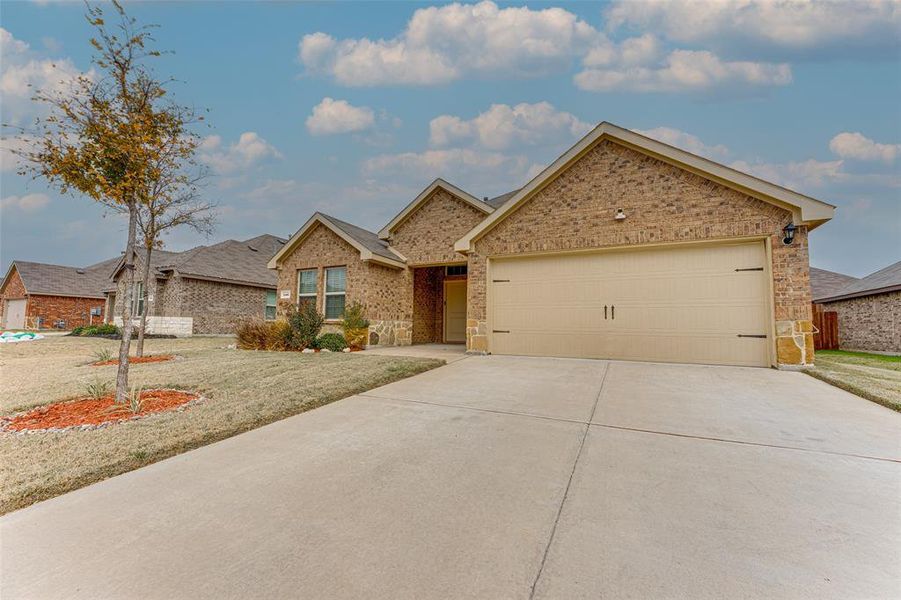 View of front of house with a garage and a front lawn