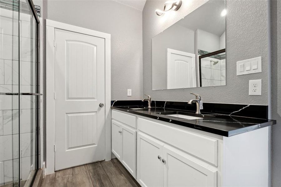 Bathroom with vanity, walk in shower, and hardwood / wood-style flooring