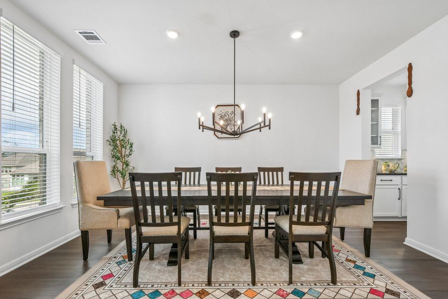 Hardwood floors and a contemporary chandelier define this elegant dining area.