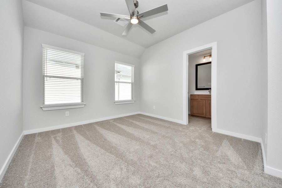 Secondary bedroom features plush carpeting, large windows that let in plenty of natural light, bright paint, and spacious closets.