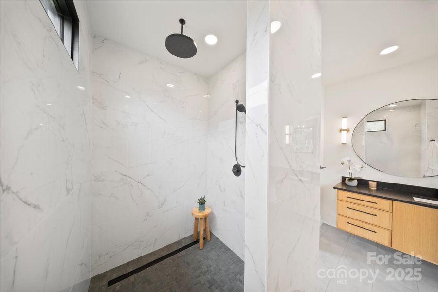 Large format porcelain shower tile with natural stone floor and linear drain Large format porcelain shower tile with natural stone floor and linear drain