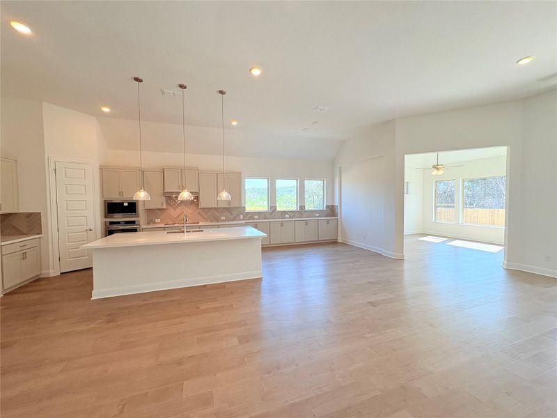 Kitchen featuring a sink, oven, built in microwave, healthy amount of natural light, and lofted ceiling Kitchen featuring a sink, oven, built in microwave, healthy amount of natural light, and lofted ceiling