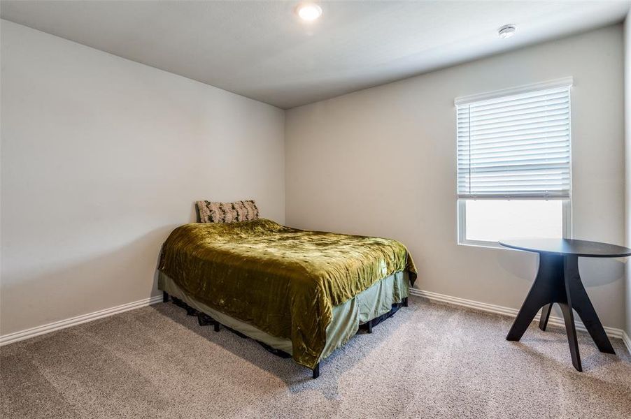 Bedroom featuring baseboards and light carpet