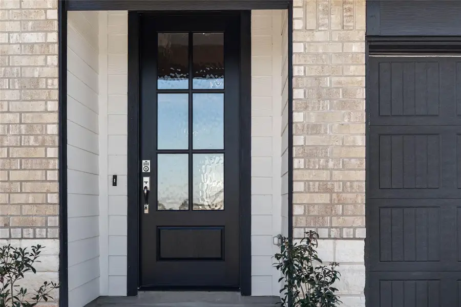 Exceptional curb appeal defines this residence. It features a gorgeous six-lite door with glass panes making it the focal point for this modern farmhouse entryway.