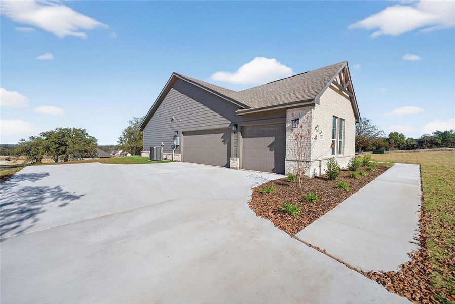 View of home's exterior with concrete driveway, brick siding, an attached garage, and a shingled roof View of home's exterior with concrete driveway, brick siding, an attached garage, and a shingled roof