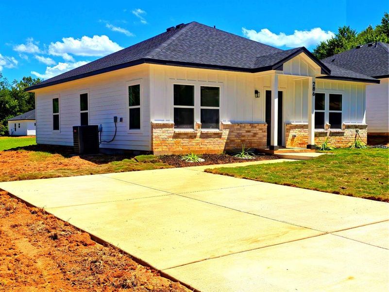 View of front of house featuring a front lawn, roof with shingles, a porch, board and batten siding, and brick siding View of front of house featuring a front lawn, roof with shingles, a porch, board and batten siding, and brick siding