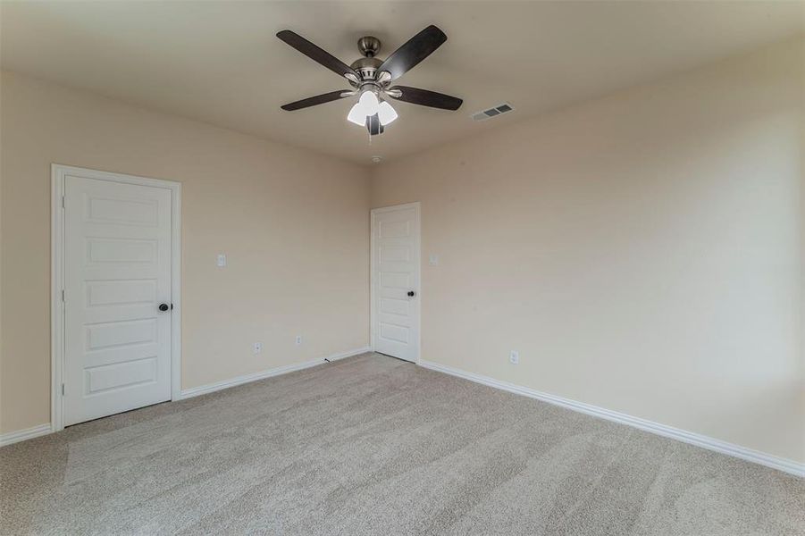 Carpeted empty room featuring ceiling fan