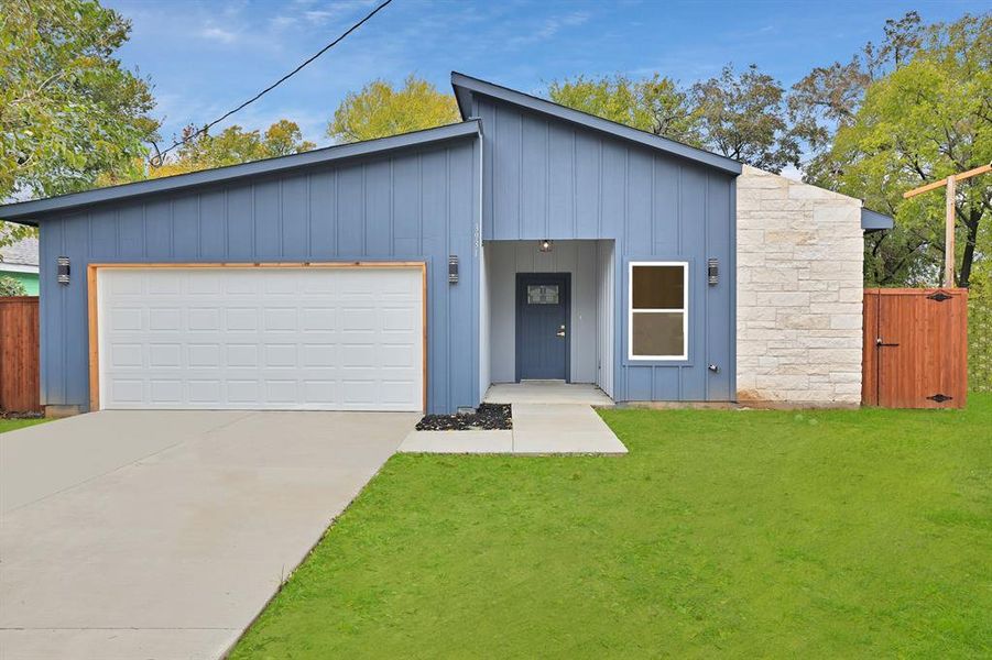 View of front of house featuring a front lawn and a garage