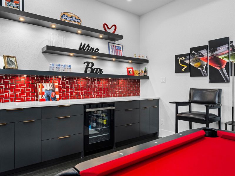 Indoor dry bar with dark cabinetry, open shelves, modern cabinets, tasteful backsplash, and beverage cooler