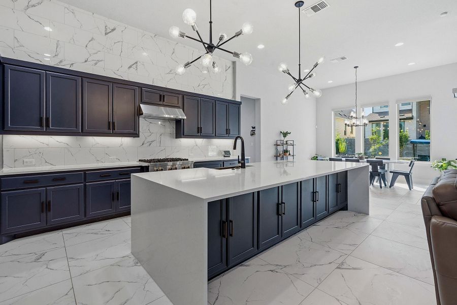 Culinary delights await in this modern kitchen with striking pendant lighting and ample counter space. Culinary delights await in this modern kitchen with striking pendant lighting and ample counter space.