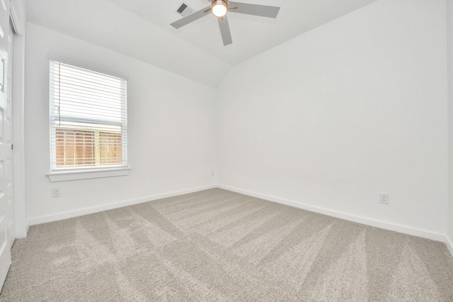 Secondary bedroom features plush carpeting, large windows that let in plenty of natural light, bright paint, and spacious closets.