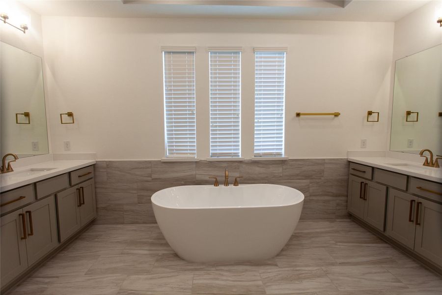 A serene bedroom paired with its own private vanity area,brushed gold hardware, and quartz countertops — comfort and convenience in one suite.