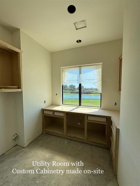 Spacious Utility Room with Custom-built Cabinetry designed on-site, complete with large window bringing in natural light and serene lake views.
