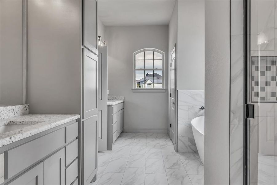 Bathroom featuring vanity and separate shower and tub