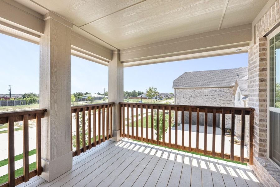 Covered second-floor balcony with wood railing, white deck boards, and neighborhood view Covered second-floor balcony with wood railing, white deck boards, and neighborhood view