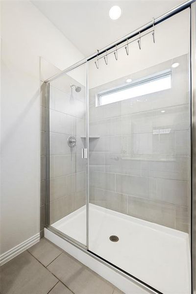 Glass-enclosed shower featuring a tiled surround, recessed shelf, and an overhead transom window Glass-enclosed shower featuring a tiled surround, recessed shelf, and an overhead transom window
