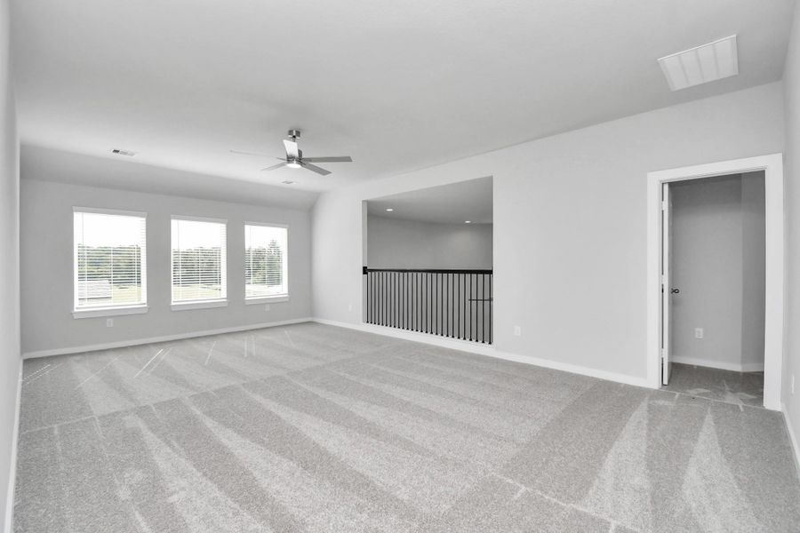 Come upstairs and enjoy a day of leisure in this fabulous game room! This is the perfect hangout spot or adult game room! Features plush carpet, high ceilings, custom paint and windows for plenty of natural light. Sample photo of completed home with similar floor plan. Actual colors and selections may vary.