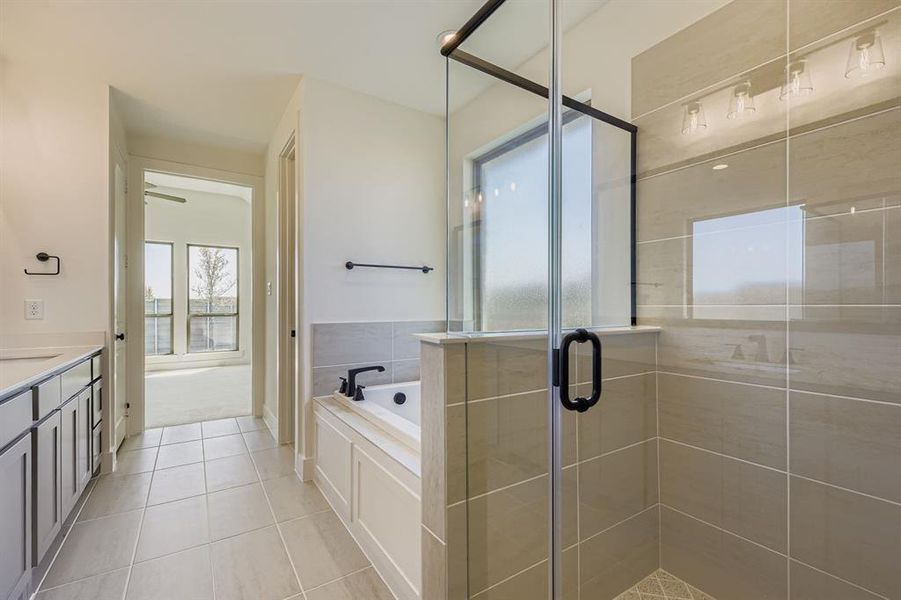 Bathroom featuring a shower stall, a bath, vanity, and light tile patterned floors Bathroom featuring a shower stall, a bath, vanity, and light tile patterned floors