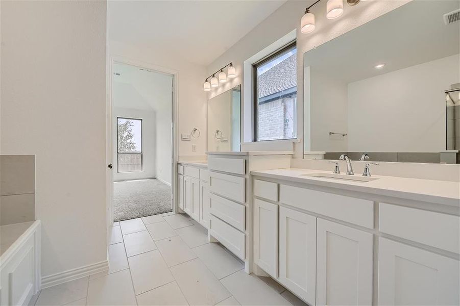 Bathroom featuring a wealth of natural light, tile flooring, and vanity