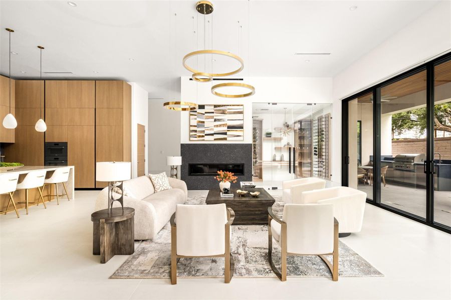 Inviting family room anchored by a sleek fireplace and statement lighting, with seamless access to the outdoor living spaces.