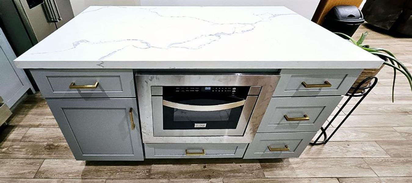 Island includes soft close drawers and pull-out microwave oven.