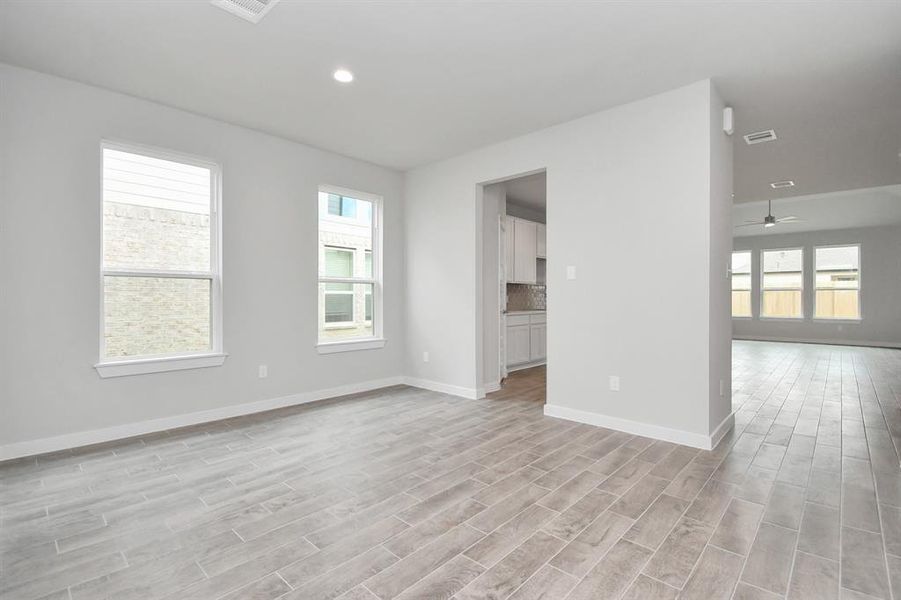 Create lasting memories with your family and friends at the dining table in this expansive dining room. Showcases sophisticated flooring, custom paint, and seamlessly connects to the family room and kitchen, providing an open and inviting atmosphere. Sample photo, actual color and selections can vary.