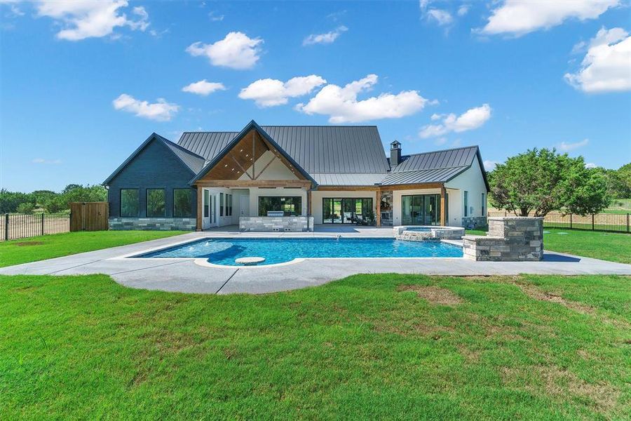 View of swimming pool with a yard, a patio area, and an in ground hot tub