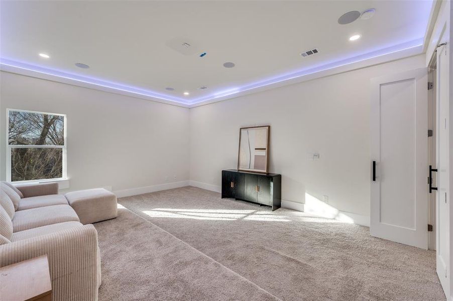 Carpeted living room featuring recessed lighting and a tray ceiling