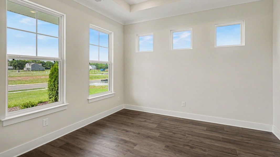 Dining space with tray ceiling, hard surface flooring, and windows Dining space with tray ceiling, hard surface flooring, and windows