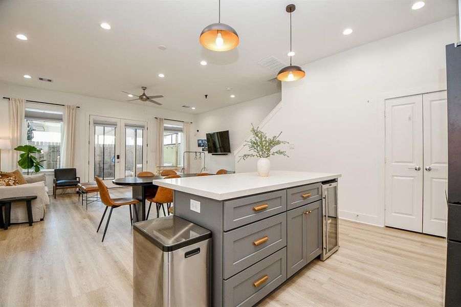 The large windows and glass doors enhance the natural light leading to a cozy patio.