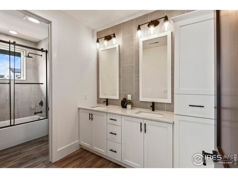 Spacious shared upper bath with dual vanities, tiled to ceiling, and tons of storage!