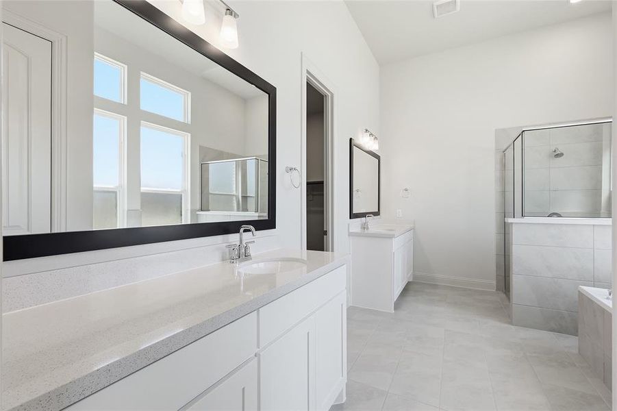 Bathroom with two vanities, a shower stall, and light tile patterned floors