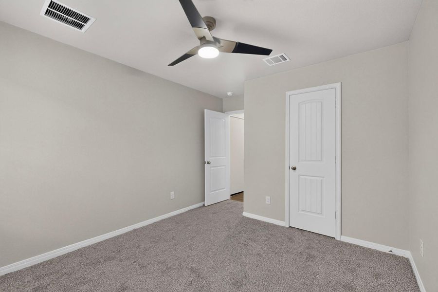 Soft carpeting underfoot creates a comfortable foundation for this versatile bedroom space.
