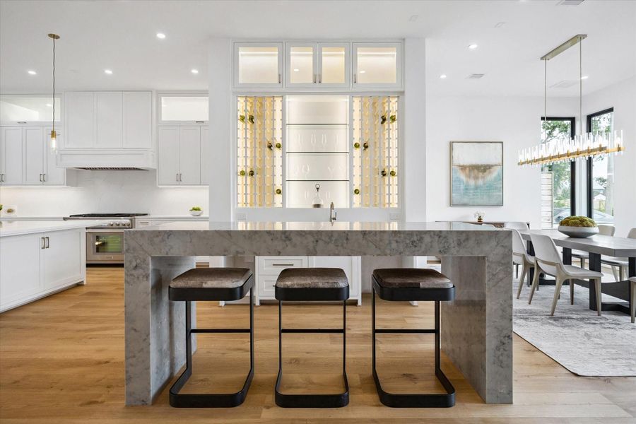 Bar and lounge area with built-in shelving, wine rack, marble counter, and seating space make this the perfect transition between the dining and the kitchen. Bar and lounge area with built-in shelving, wine rack, marble counter, and seating space make this the perfect transition between the dining and the kitchen.