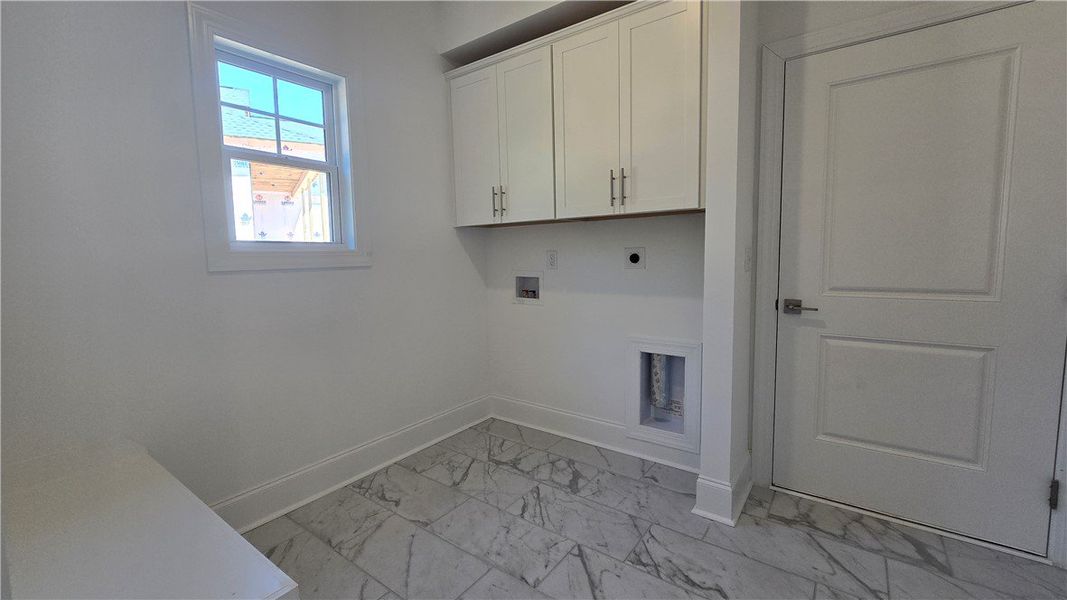 A well-appointed laundry room awaits with ample ca