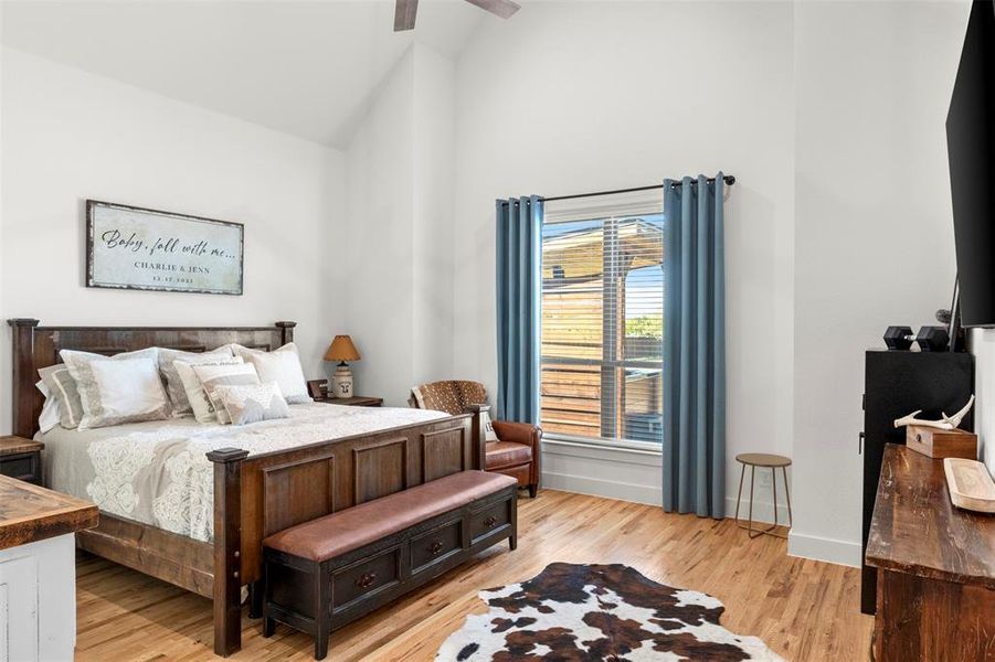 Bedroom featuring hard wood flooring, sitting area, and high vaulted ceiling