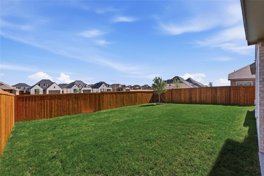 Fenced backyard featuring a residential view