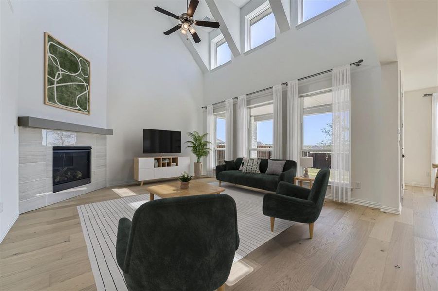 Virtually Staged Photo - Living room featuring high vaulted ceiling, ceiling fan, light hardwood / wood-style floors, and a fireplace