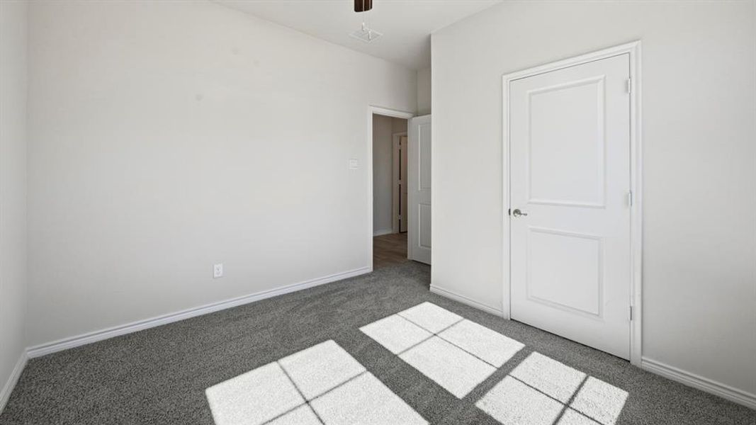Unfurnished bedroom featuring carpet and a ceiling fan Unfurnished bedroom featuring carpet and a ceiling fan