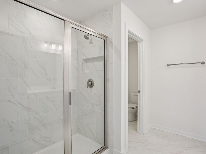 The primary bathroom offers dual vanity sinks and a walk-in shower.