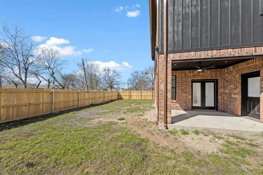 View of yard featuring a patio area, ceiling fan, a fenced backyard, and french doors